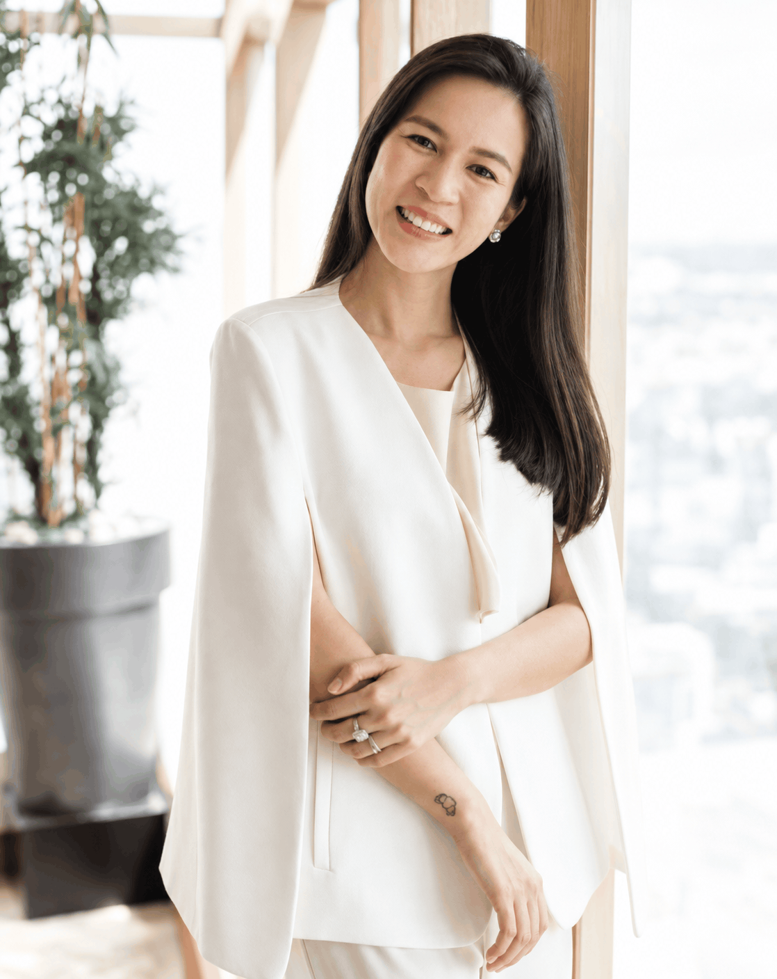 Candid half-body portrait of Paola, the founder and creative strategist in a white tailored coat
